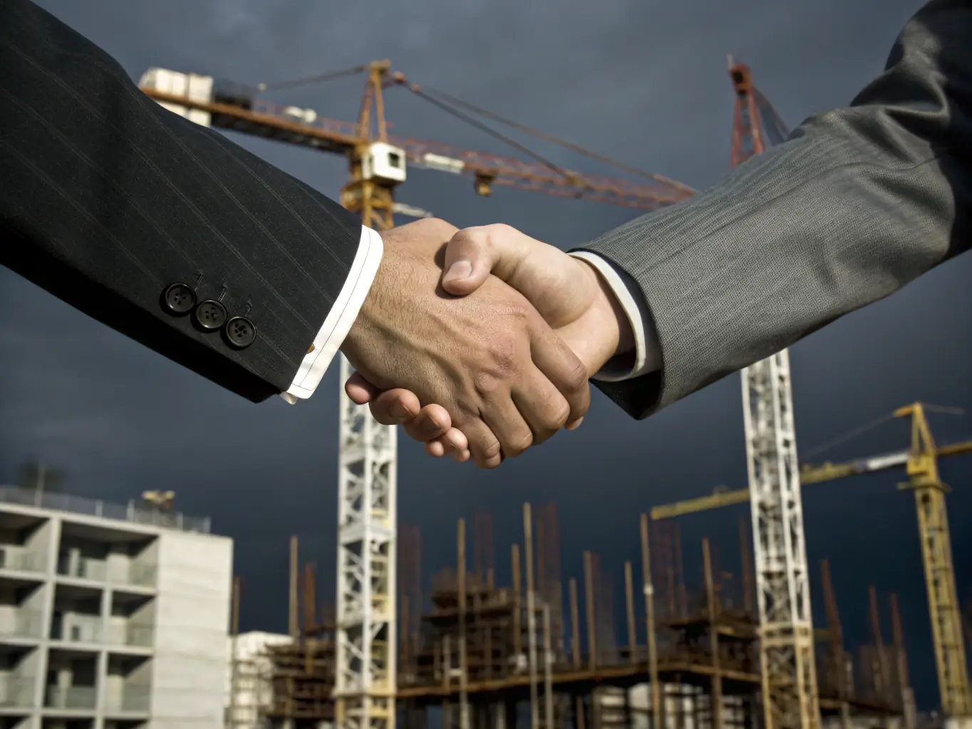 A photograph depicting a handshake between two business partners in front of a modern office building, representing the strategic partnerships facilitated by DealPantry Africa.